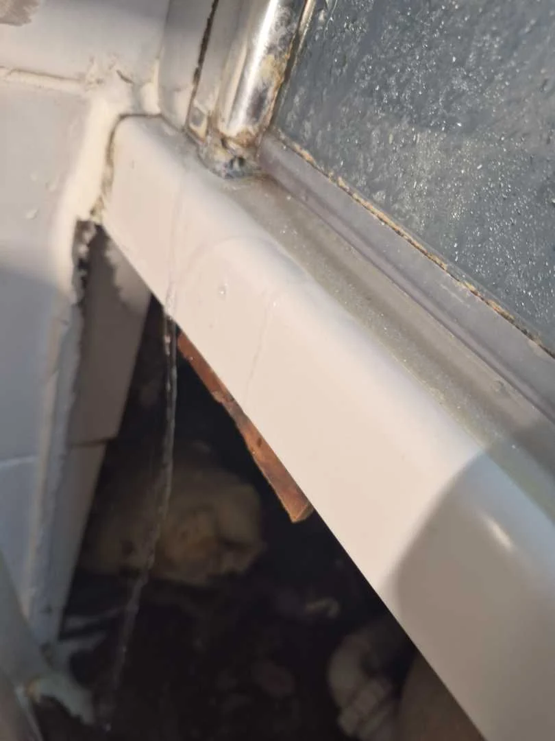 Water at the base of a bath screen during the Coventry spray test